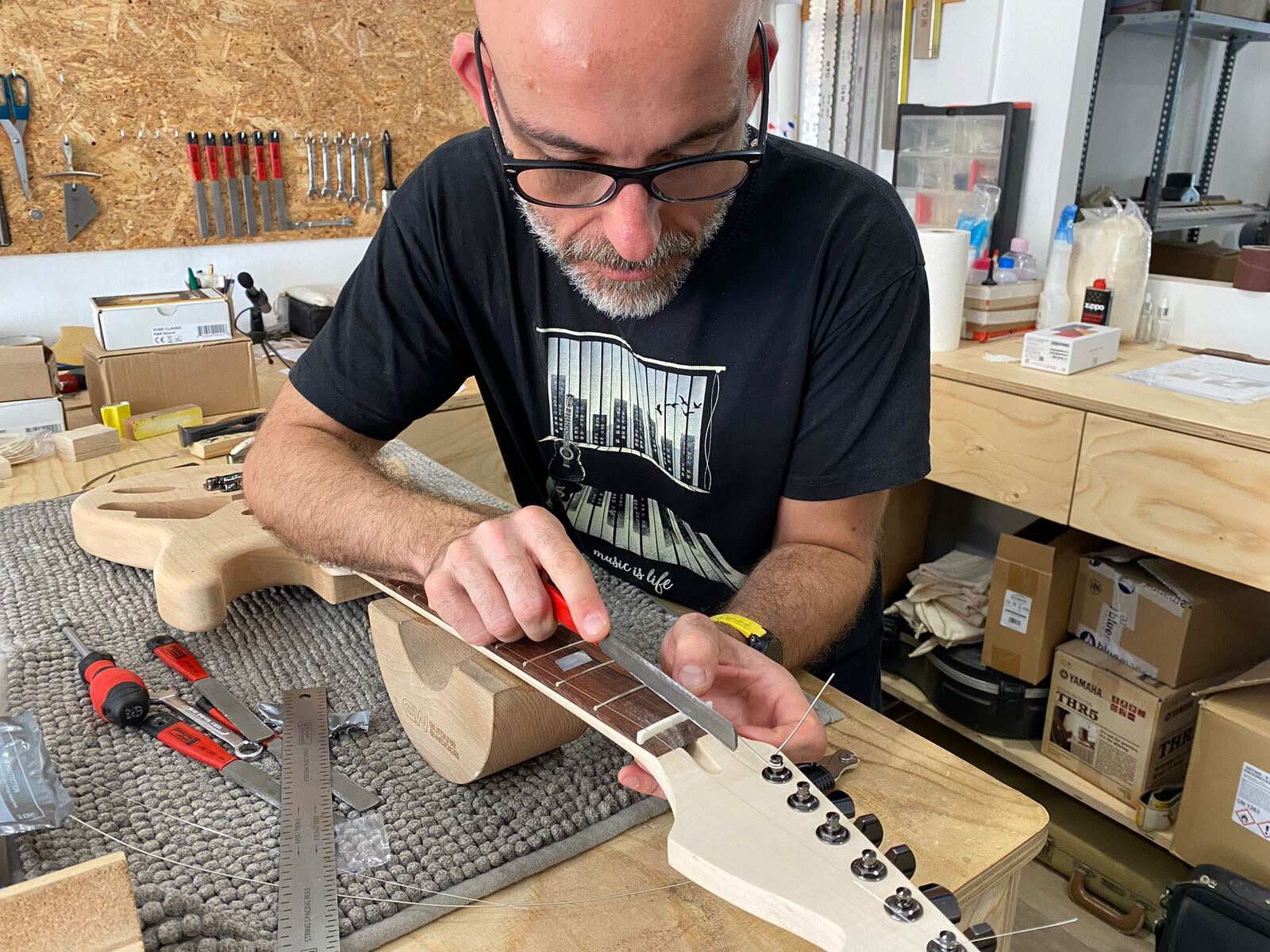 Pau con su guitarra en el taller